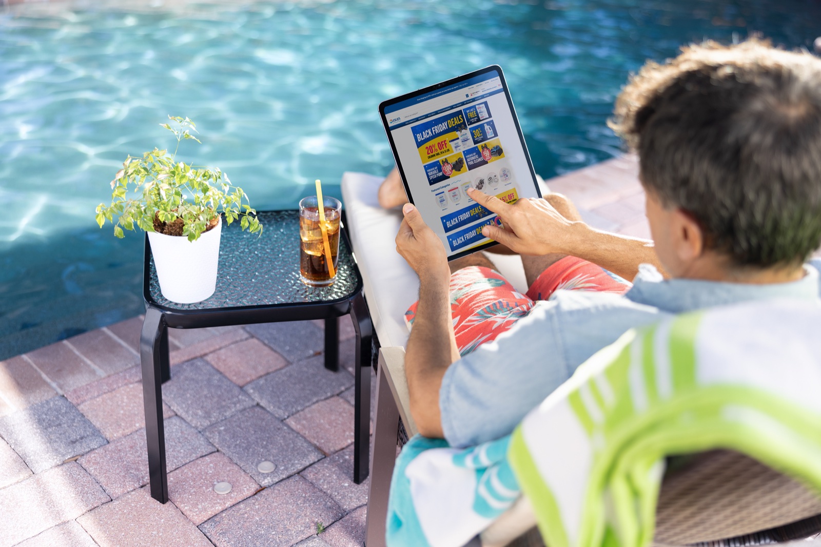 Customer browsing Leslie’s campaign creative on an iPad beside a pool