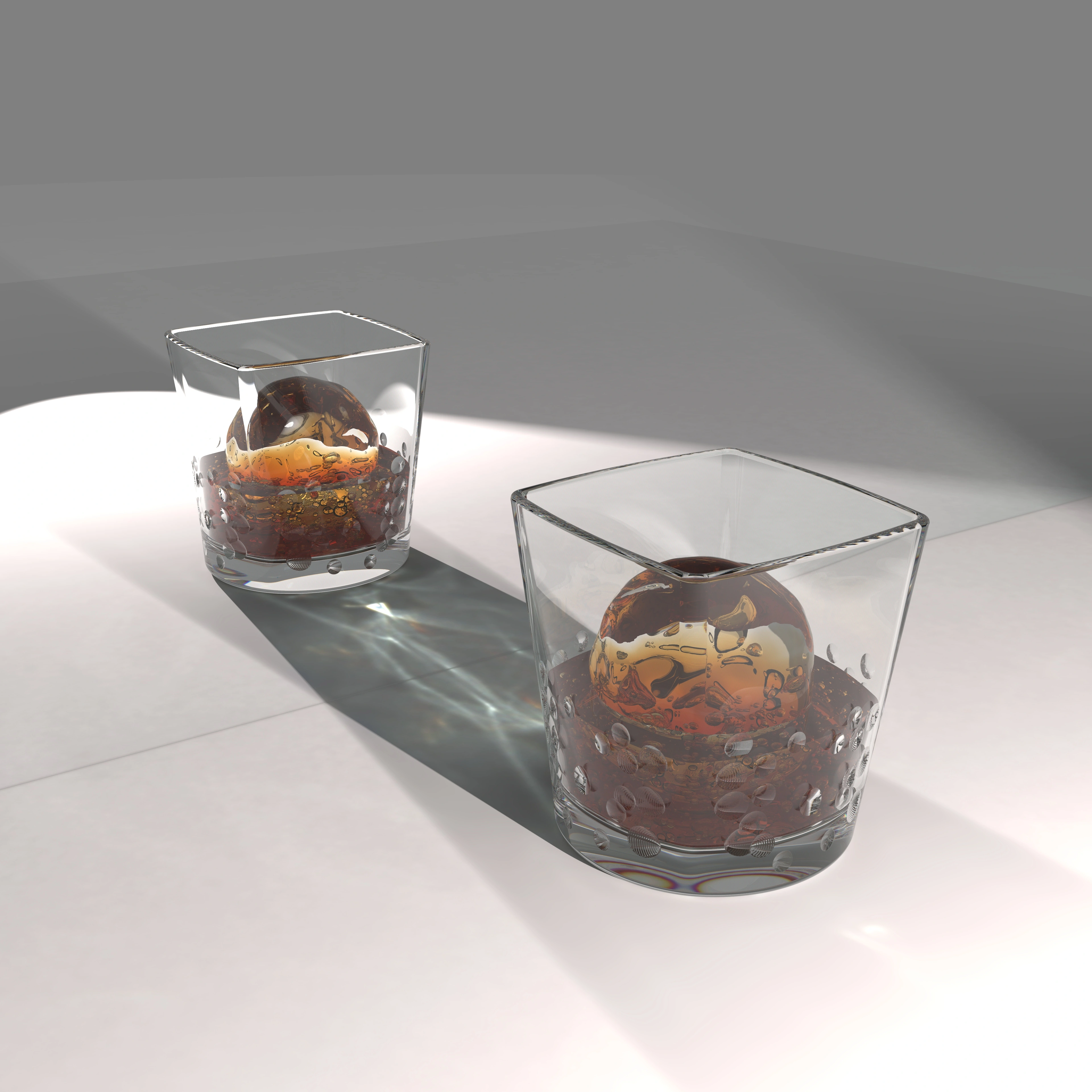 Two glass tumblers with spherical ice forms and strong directional shadows